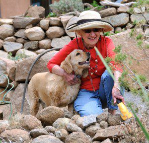 An avid gardener at her Piños Altos home, Port Laureate Bonnie Maldonado is joined by Murphy, one of three rescue dogs and two cats owned by Bonnie and her husband Librado. (Photo by Harry Williamson)